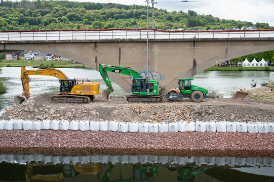 Construction site, excavators and road roller, temporary bank reinforcement, sandbags and crushed stone, bridge Wasserbillig, Luxembourg