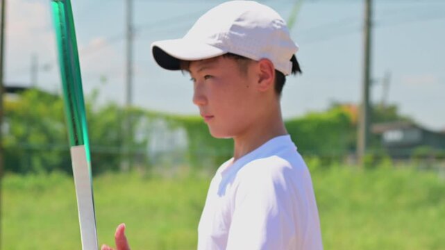テニスラケットを回す学生選手