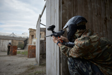 Obraz premium A soldier is taking a defensive position behind the cover during tactical weapon training