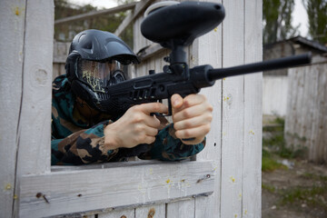 Obraz premium A soldier aims a weapon while looking out of a window on a training field