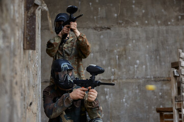 Obraz premium Two soldiers aim their weapons while taking up comfortable positions on a training field