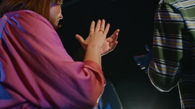 Caucasian young woman clapping hands with peers during student theater performance from low angle. Clip suited for promoting drama education and stage arts