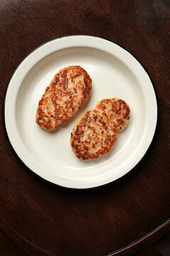Two fried chicken cutlets on enamel plate flat lay