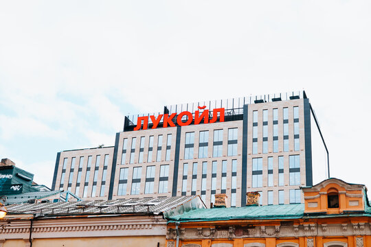  large building towers over the surrounding structures in a busy urban setting. The visible sign on top displays a name Lukoil