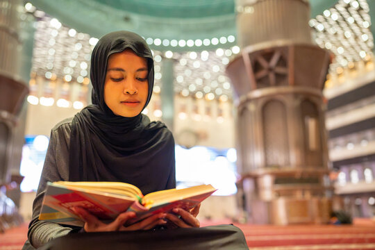 Muslim woman reading holy quran in mosque