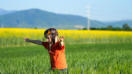 Child with aviator helmet and eyeglasses play in nature, dreams come true © MEDIAIMAG