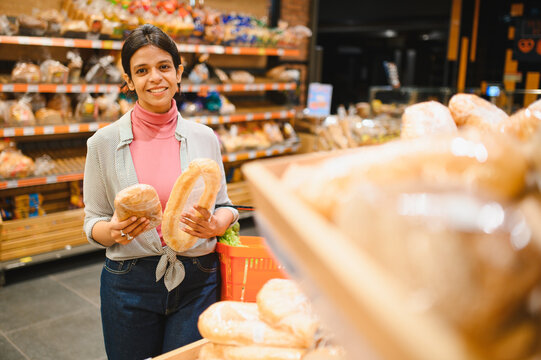 Indian woman shopping for fresh bread in supermarket