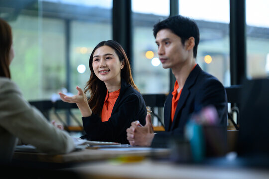 Asian Business Professionals Discussing in Modern Office Meeting Room