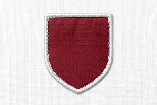 Blank maroon shield embroidered patch with a white stitched border on a white fabric background. Empty crest emblem template perfect for custom logo mockups.