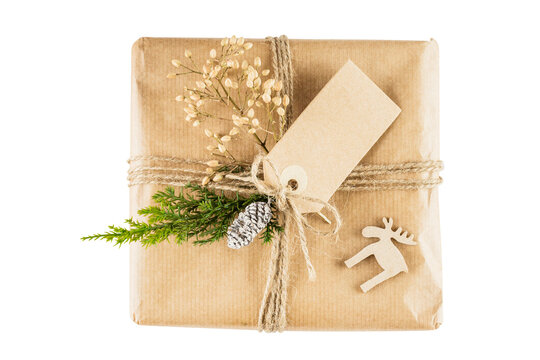 Rustic Christmas gift box wrapped in craft paper with pine branch and blank tag