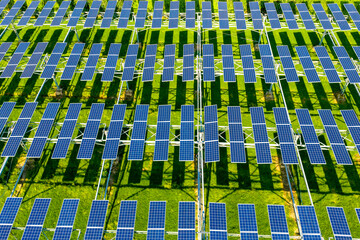 rows of blue solar panels on green grass field © zhangyang135769