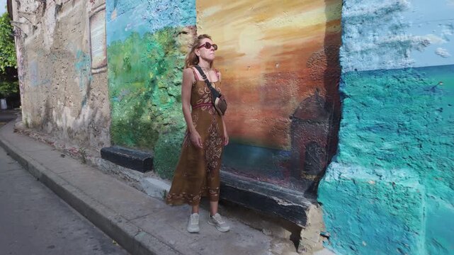 Woman checking a map on her phone while walking in Getsemani, Cartagena, Colombia, hesitating and turning back before confidently continuing her way, travel navigation concept