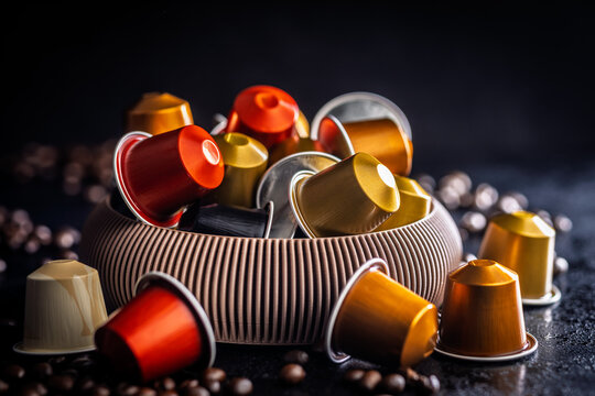 Colorful Coffee Pods And Capsules In A Bowl With Scattered Coffee Beans On Dark Background