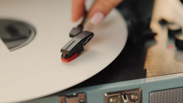 Enjoying music on a vinyl record player in a cozy home setting with a focus on the turntable