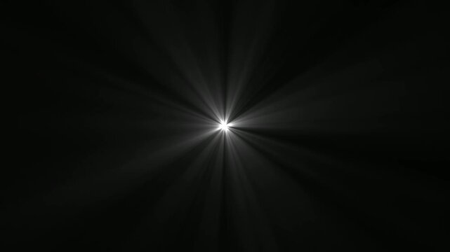 Abstract bright white light flare with radial rays emanating from center on a solid black background