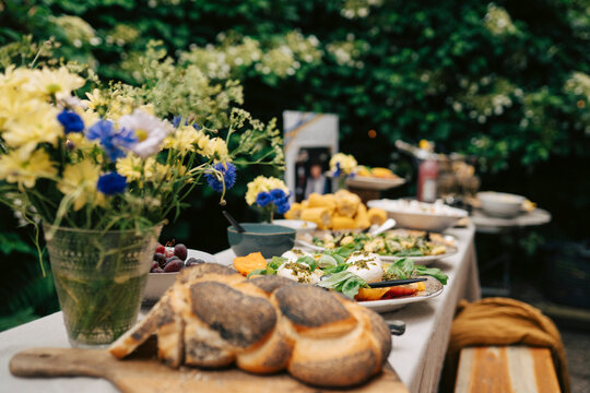 Variety of healthy food and fresh dishes arranged on dining table in back yard