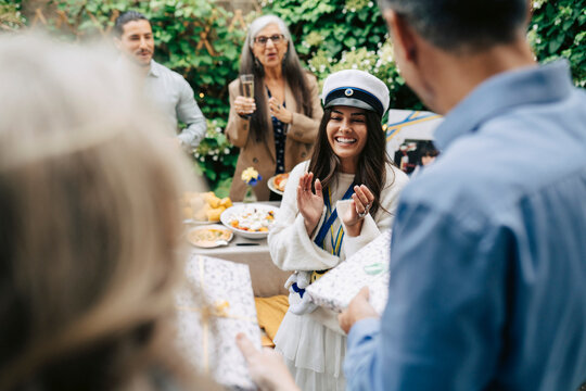 Happy young woman clapping during her graduation celebration