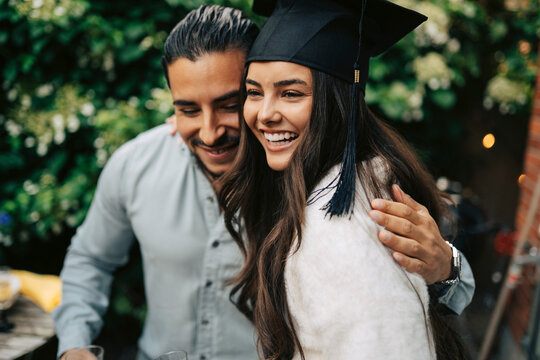 Happy woman embracing relative during her graduation celebration party