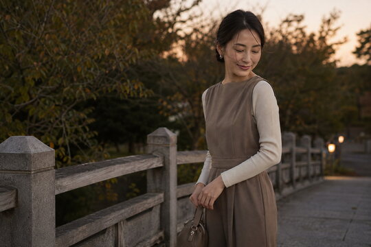 公園橋の夕光に振り向くモカの女性