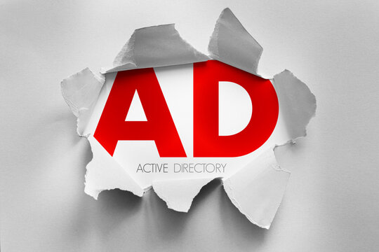 AD Active Directory text shown through torn paper background, enterprise technology concept representing centralized user authentication, access management and network administration