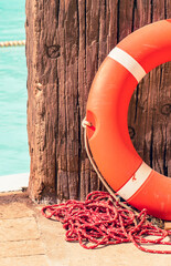 Orange life buoy hanging on a weathered wooden wall © rumata79