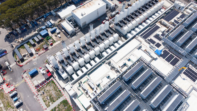 Aerial view of Vantage VDC MXP2 data center facility with rows of cooling units, solar panels on rooftops, and industrial infrastructure in Castelletto, Lombardia, Italy.