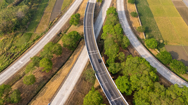 Aerial view of a highway interchange surrounded by lush green trees and agricultural fields in Boyolali, Central Java, Indonesia.