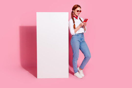 Full length photo of shiny sweet lady dressed cowboy outfit chatting instagram twitter telegram facebook emtpy space isolated pink color background