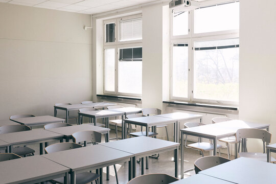 Empty desks and chairs in classroom at high school