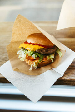 Close-up shot of cheeseburger wrapped in brown paper
