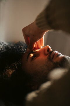 Close-up shot of anxious man touching his forehead at home