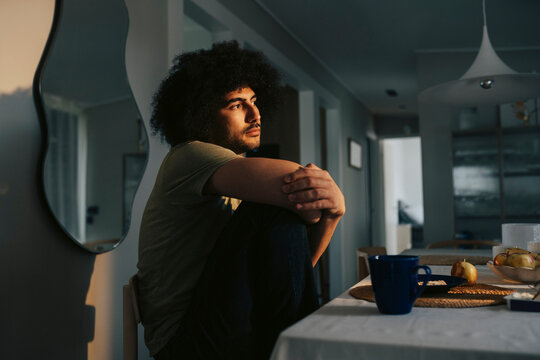 Thoughtful man contemplating while sitting at dining table