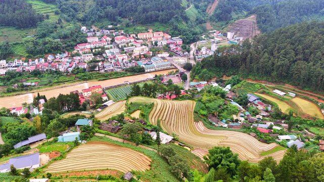 Aerial drone view of a hillside village surrounded by thick morning mist in Mu Cang Chai Vietnam