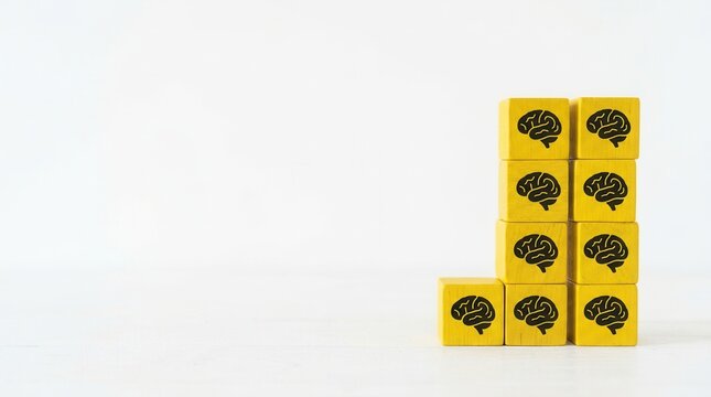 Stacking yellow blocks with brain icons, symbolizing knowledge, learning, intelligence, and growth.