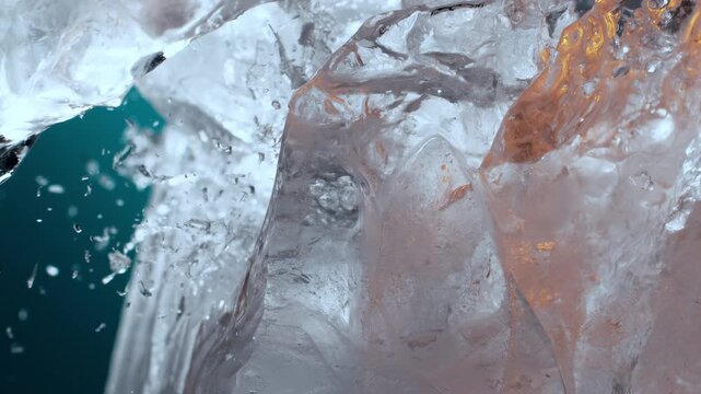 Ice being shattered by an ice pick in extreme macro close-up, capturing sharp cracks, flying ice fragments and sparkling frozen textures in dramatic slow motion.