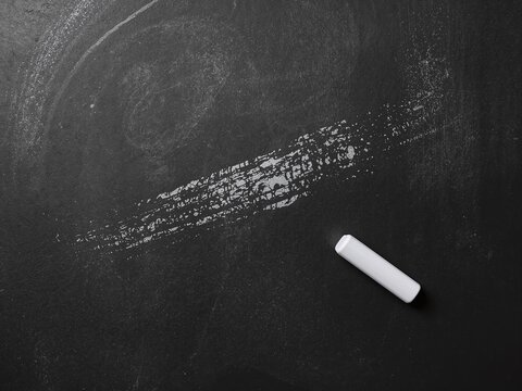 Generative AI depicts a chalkboard with faint markings and a chalk piece