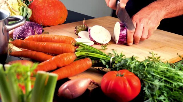 hands chopping fresh vegetables on wooden cutting board, cooking preparation