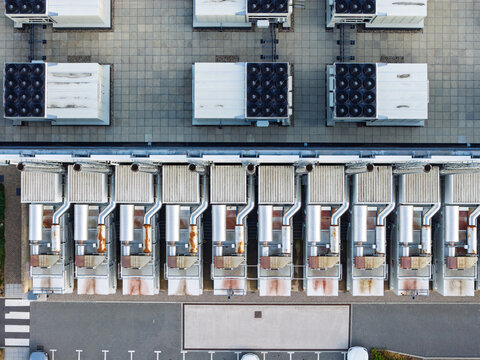 Aerial view of a data center roof featuring rows of industrial HVAC cooling units, ventilation pipes, and technical infrastructure in the United Kingdom.