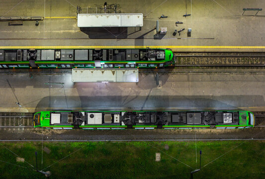 Aerial view of Jana III Sobieskiego Bus and Tram Terminal with green trams parked at the platforms at night in Poznan, Greater Poland Voivod, Poland.
