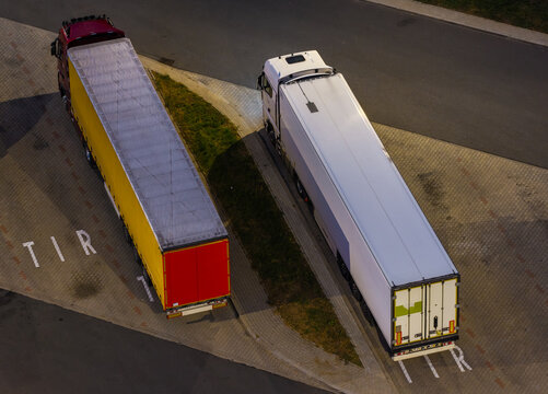 Aerial view of two semi-trucks parked at the Gajewo East Motorway Service Area on the A1 Motorway with paved parking and TIR markings in Nowe, Kuyavian-Pomeranian, Poland.