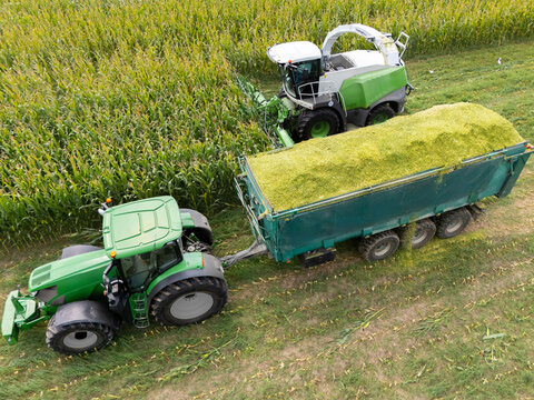 Aerial view of a forage harvester collecting corn and loading it into a tractor trailer