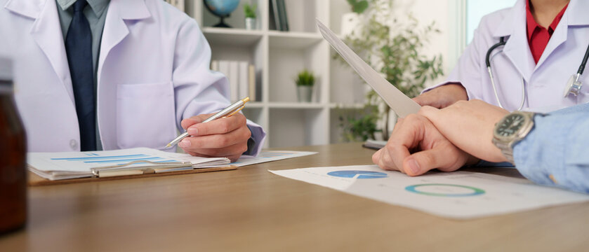 Doctors hands reviewing medical charts and reports during patient consultation
