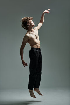 Athletic male dancer jumping in studio