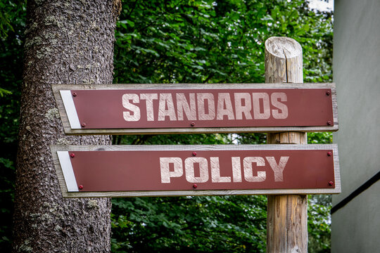 STANDARDS and POLICY Signs on a Wooden Post Beside a Tree