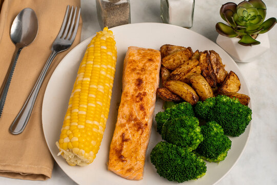 saesoned salmon with   steamed broccoli and corn
