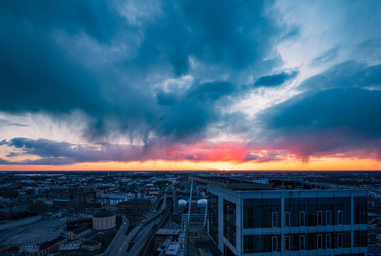 Aerial view of Kalasatama towers overlooking the city skyline during a dramatic sunset with vibrant clouds and rain showers in the distance, Helsinki, Uusimaa, Finland.