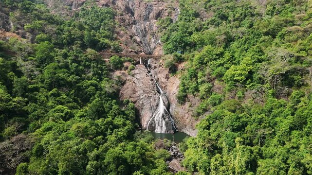 Dudhsagar falls aerial view with a railway bridge crossing over the waterfall in the western ghats jungle of goa, india