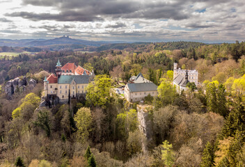Fototapeta premium Aerial view of Bohemian Paradise in the Czech Republic. View of a castle surrounded by rocks and forest in the national park. Sunny day with mountains, forests, and a castle.