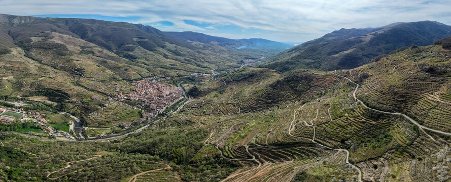 Aerial view of the historic town of Cabezuela del Valle nestled in the Jerte Valley, surrounded by terraced hillsides and winding mountain roads in Cabezuela del Valle, Extremadura, Spain.