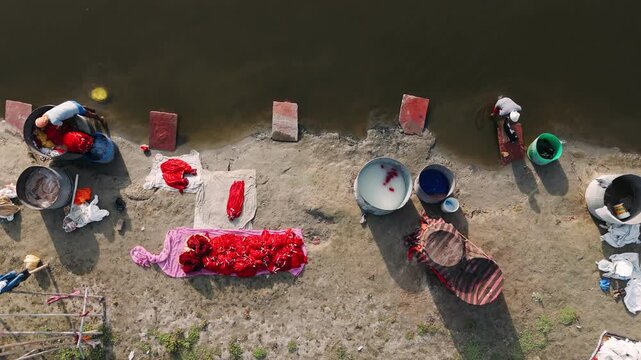 Aerial view of an indian dhobi washing clothes by hand in yamuna river in india